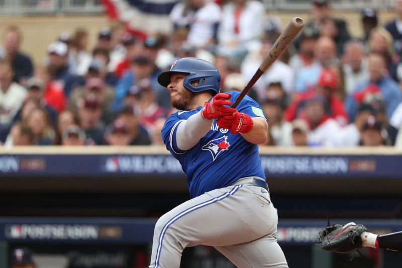 Oct 4, 2023; Minneapolis, Minnesota, USA; Toronto Blue Jays catcher Alejandro Kirk (30) hits a single in the second inning against the Minnesota Twins during game two of the Wildcard series for the 2023 MLB playoffs at Target Field. Mandatory Credit: Jesse Johnson-USA TODAY Sports