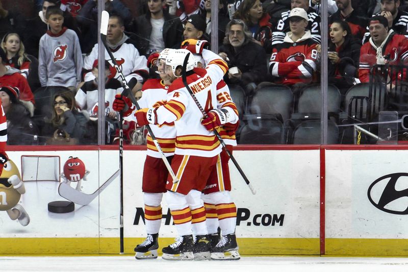 Feb 8, 2024; Newark, New Jersey, USA; Calgary Flames center Connor Zary (47) celebrates with teammates after scoring a goal against the New Jersey Devils during the second period at Prudential Center. Mandatory Credit: John Jones-USA TODAY Sports