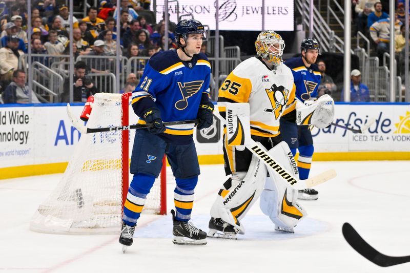 Apr 3, 2025; St. Louis, Missouri, USA;  St. Louis Blues right wing Jimmy Snuggerud (21) skates next to Pittsburgh Penguins goaltender Tristan Jarry (35) during the second period at Enterprise Center. Mandatory Credit: Jeff Curry-Imagn Images