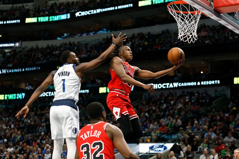 DALLAS, TEXAS - APRIL 07: Ayo Dosunmu #12 of the Chicago Bulls drives to the basket against Theo Pinson #1 of the Dallas Mavericks in the fourth quarter at American Airlines Center on April 07, 2023 in Dallas, Texas. NOTE TO USER: User expressly acknowledges and agrees that, by downloading and or using this photograph, User is consenting to the terms and conditions of the Getty Images License Agreement. (Photo by Tim Heitman/Getty Images)