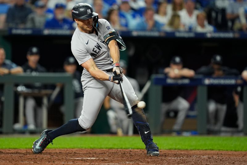 Oct 9, 2024; Kansas City, Missouri, USA; New York Yankees designated hitter Giancarlo Stanton (27) hits a home run in the eighth inning against the Kansas City Royals during game three of the NLDS for the 2024 MLB Playoffs at Kauffman Stadium. Mandatory Credit: Jay Biggerstaff -Imagn Images