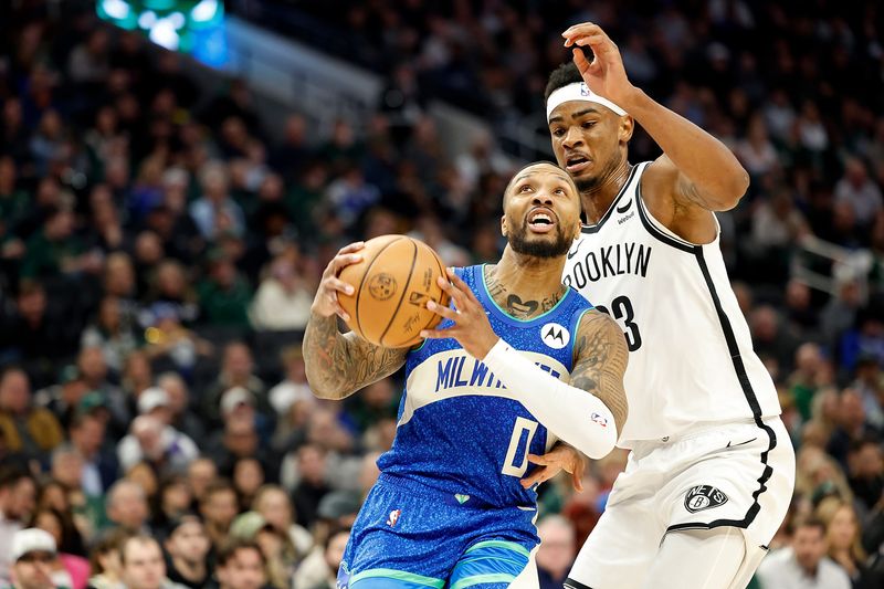 MILWAUKEE, WISCONSIN - MARCH 21: Damian Lillard #0 of the Milwaukee Bucks scores drives to the basket on Nic Claxton #33 of the Brooklyn Nets during the first half of the game at Fiserv Forum on March 21, 2024 in Milwaukee, Wisconsin. NOTE TO USER: User expressly acknowledges and agrees that, by downloading and or using this photograph, User is consenting to the terms and conditions of the Getty Images License Agreement. (Photo by John Fisher/Getty Images)