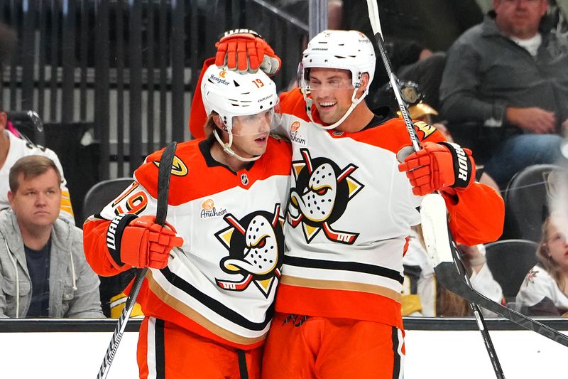 Oct 13, 2024; Las Vegas, Nevada, USA; Anaheim Ducks right wing Troy Terry (19) celebrates with defenseman Brian Dumoulin (6) after scoring a goal against the Vegas Golden Knights during the first period at T-Mobile Arena. Mandatory Credit: Stephen R. Sylvanie-Imagn Images