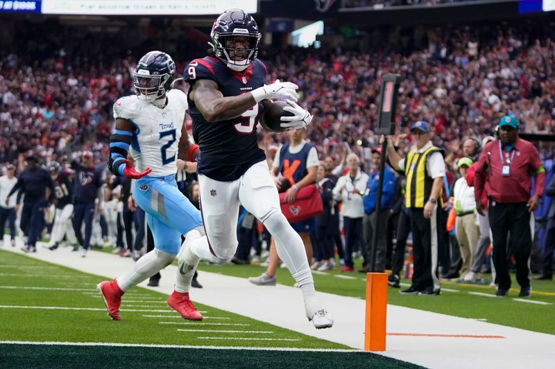 Houston Texans tight end Brevin Jordan (9) runs into the end zone for a touchdown past Tennessee Titans linebacker Azeez Al-Shaair (2) during the first half of an NFL football game Sunday, Dec. 31, 2023, in Houston. (AP Photo/Eric Christian Smith)