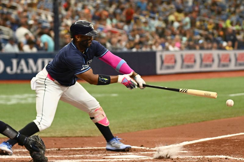 Jun 26, 2024; St. Petersburg, Florida, USA; Tampa Bay Rays first baseman Yandy Diaz (2) hits a RBI single against the Seattle Mariners in the third inning at Tropicana Field. Mandatory Credit: Jonathan Dyer-USA TODAY Sports