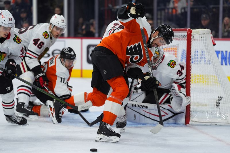 Nov 23, 2024; Philadelphia, Pennsylvania, USA; Philadelphia Flyers left wing Noah Cates (27) reaches for a loose puck against the Chicago Blackhawks in the third period at Wells Fargo Center. Mandatory Credit: Kyle Ross-Imagn Images