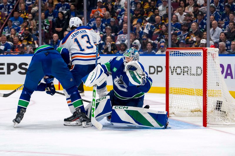 May 10, 2024; Vancouver, British Columbia, CAN; Vancouver Canucks goalie Arturs Silvos (31) makes a save as defenseman Nikita Zadorov (91) battles with Edmonton Oilers forward Mattias Janmark (13) during the first overtime in game two of the second round of the 2024 Stanley Cup Playoffs at Rogers Arena. Mandatory Credit: Bob Frid-USA TODAY Sports