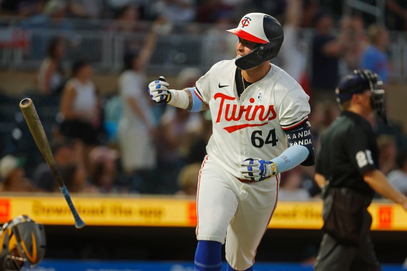 Jun 16, 2024; Minneapolis, Minnesota, USA; Minnesota Twins designated hitter Jose Miranda (64) flips his bat after hitting a solo home run against the Oakland Athletics in the eighth inning of game two of a double header at Target Field. Mandatory Credit: Bruce Kluckhohn-USA TODAY Sports