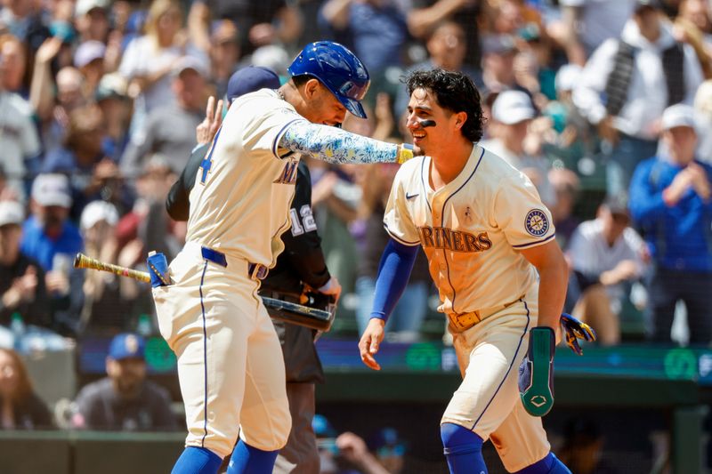 Jun 16, 2024; Seattle, Washington, USA; Seattle Mariners third baseman Josh Rojas (4, right) celebrates with center fielder Julio Rodriguez (44) after scoring a run on a wild pitch against the Texas Rangers during the fifth inning at T-Mobile Park. Mandatory Credit: Joe Nicholson-USA TODAY Sports