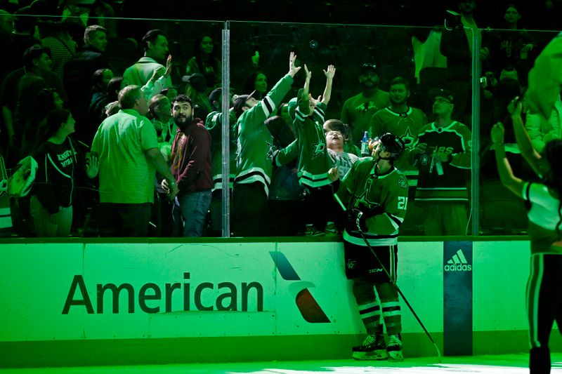 Mar 22, 2024; Dallas, Texas, USA; Dallas Stars left wing Jason Robertson (21) tosses a puck to the fans after the Stars defeat the Pittsburgh Penguins at the American Airlines Center. Mandatory Credit: Jerome Miron-USA TODAY Sports