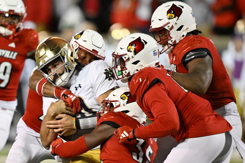 Oct 7, 2023; Louisville, Kentucky, USA;  Notre Dame Fighting Irish quarterback Sam Hartman (10) is wrapped up by four Louisville Cardinals defenders during the second half at L&N Federal Credit Union Stadium. Louisville defeated Notre Dame 33-20. Mandatory Credit: Jamie Rhodes-USA TODAY Sports