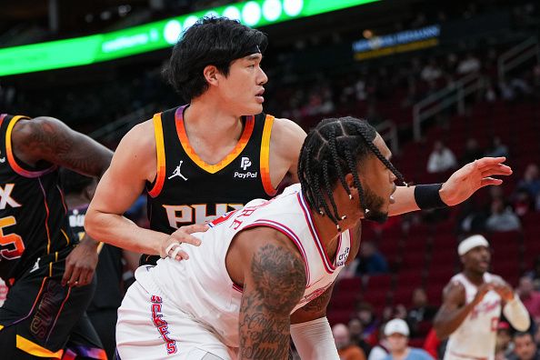 HOUSTON, TEXAS - DECEMBER 27: Yuta Watanabe #18 of the Phoenix Suns defends Cam Whitmore #7 of the Houston Rockets during the game at Toyota Center on December 27, 2023 in Houston, Texas. User expressly acknowledges and agrees that, by downloading and or using this photograph, User is consenting to the terms and conditions of the Getty Images License Agreement. (Photo by Alex Bierens de Haan/Getty Images)