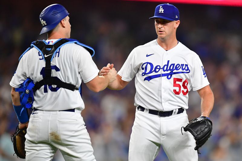 Jul 29, 2023; Los Angeles, California, USA; Los Angeles Dodgers catcher Will Smith (16) and relief pitcher Evan Phillips (59) celebrate the victory against the Cincinnati Reds at Dodger Stadium. Mandatory Credit: Gary A. Vasquez-USA TODAY Sports