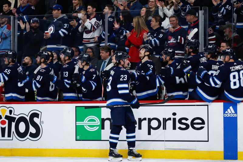 Feb 27, 2024; Winnipeg, Manitoba, CAN; Winnipeg Jets forward Sean Monahan (23) is congratulated by his team mates on his goal against the St. Louis Blues during the first period at Canada Life Centre. Mandatory Credit: Terrence Lee-USA TODAY Sports