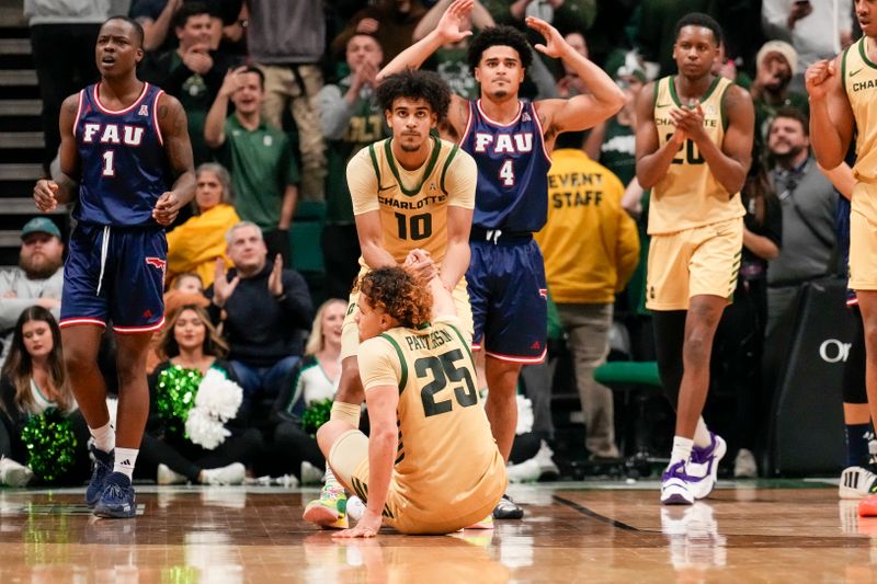 Jan 6, 2024; Charlotte, North Carolina, USA; Florida Atlantic Owls guard Bryan Greenlee (4) reacts to fouling Charlotte 49ers guard Lu'Cye Patterson (25) as guard Nik Graves (10) helps him from the floor during the second half at Dale F. Halton Arena. Mandatory Credit: Jim Dedmon-USA TODAY Sports