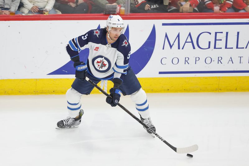 Feb 23, 2024; Chicago, Illinois, USA; Winnipeg Jets defenseman Brenden Dillon (5) looks to pass the puck against the Chicago Blackhawks during the first period at United Center. Mandatory Credit: Kamil Krzaczynski-USA TODAY Sports