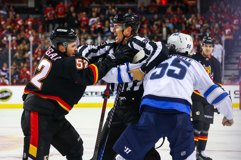 Oct 26, 2024; Calgary, Alberta, CAN; Calgary Flames defenseman MacKenzie Weegar (52) and Winnipeg Jets center Mark Scheifele (55) fights during the third period at Scotiabank Saddledome. Mandatory Credit: Sergei Belski-Imagn Images