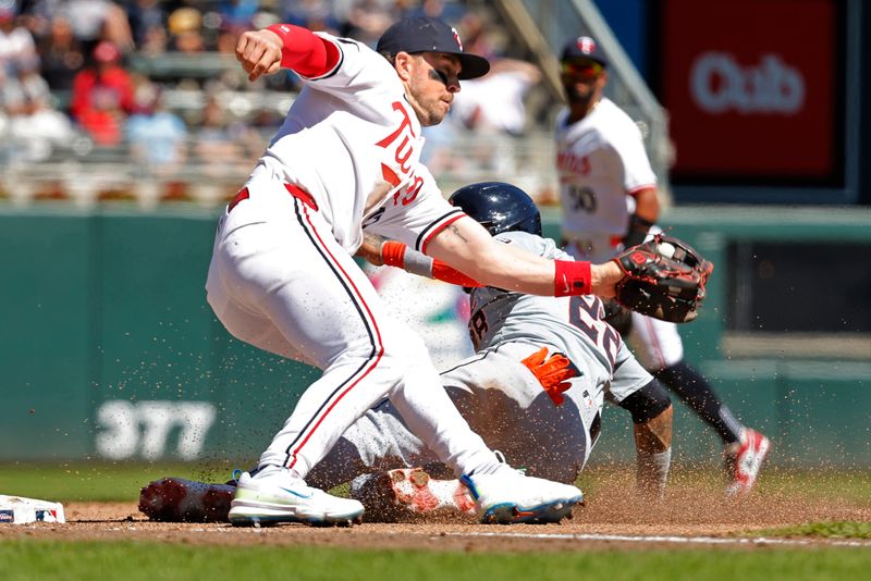 Apr 21, 2024; Minneapolis, Minnesota, USA; Minnesota Twins third baseman Kyle Farmer (12) catches a throw but not in time to catch Detroit Tigers shortstop Javier Baez (28) who steals third base in the fourth inning at Target Field. Mandatory Credit: Bruce Kluckhohn-USA TODAY Sports