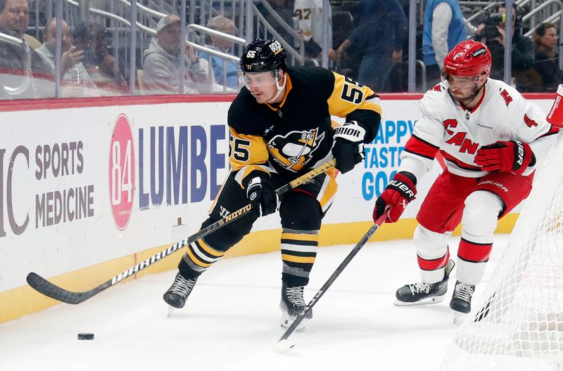 Oct 18, 2024; Pittsburgh, Pennsylvania, USA;  Pittsburgh Penguins center Noel Acciari (55) moves the puck against Carolina Hurricanes defenseman Shayne Gostisbehere (4) during the third period at PPG Paints Arena. Mandatory Credit: Charles LeClaire-Imagn Images