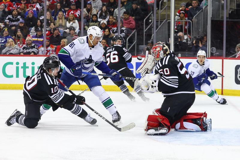 Jan 6, 2024; Newark, New Jersey, USA; New Jersey Devils goaltender Nico Daws (50) makes a save against the Vancouver Canucks during the third period at Prudential Center. Mandatory Credit: Ed Mulholland-USA TODAY Sports