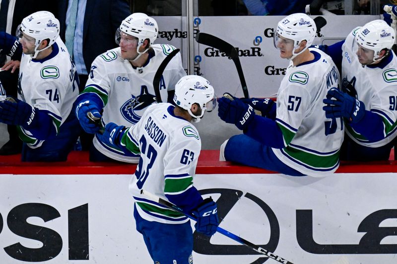 Oct 17, 2025; Chicago, Illinois, USA;  Vancouver Canucks center Max Sasson (63) celebrates after he scores past Chicago Blackhawks goaltender Spencer Knight (30) during the second period at the United Center. Mandatory Credit: Matt Marton-Imagn Images