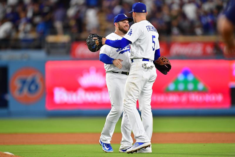 Jul 29, 2023; Los Angeles, California, USA; Los Angeles Dodgers third baseman Max Muncy (13) and first baseman Freddie Freeman (5) celebrate the victory against the Cincinnati Reds at Dodger Stadium. Mandatory Credit: Gary A. Vasquez-USA TODAY Sports