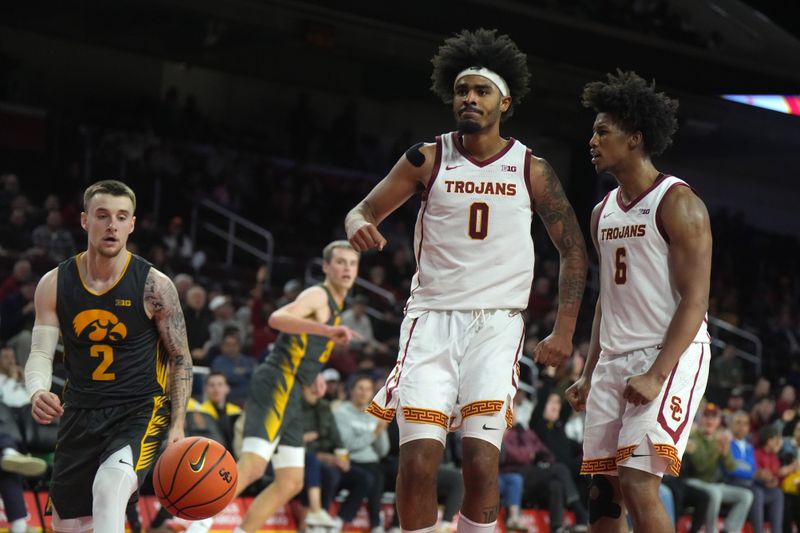 Jan 14, 2025; Los Angeles, California, USA; Southern California Trojans forward Saint Thomas (0) and guard Wesley Yates III (6) and Iowa Hawkeyes guard Brock Harding (2) react in the second half at the Galen Center. Mandatory Credit: Kirby Lee-Imagn Images