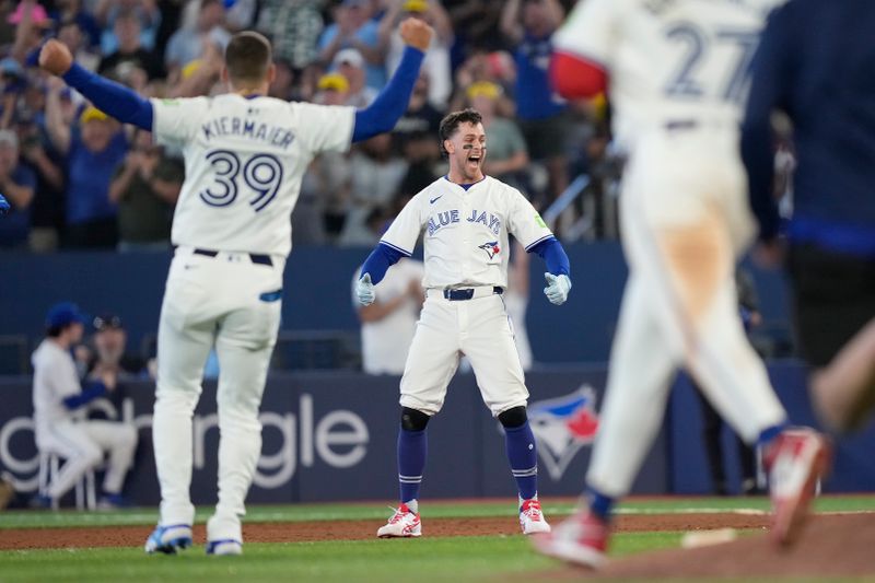 Jul 26, 2024; Toronto, Ontario, CAN; Toronto Blue Jays third baseman Ernie Clement (center) reacts after his walk off single to win the game against he Texas Rangers in the ninth inning at Rogers Centre. Mandatory Credit: John E. Sokolowski-USA TODAY Sports