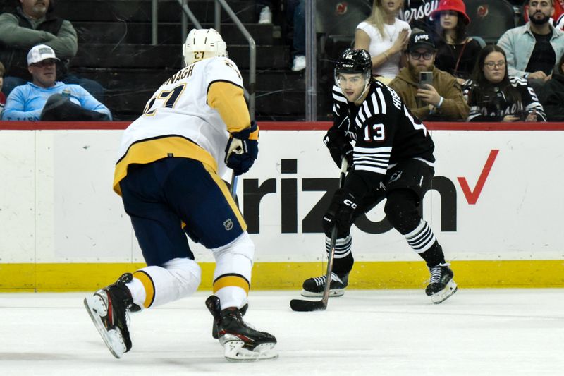 Apr 7, 2024; Newark, New Jersey, USA; New Jersey Devils center Nico Hischier (13) skates with the puck while being defended by Nashville Predators defenseman Ryan McDonagh (27) during the second period at Prudential Center. Mandatory Credit: John Jones-USA TODAY Sports