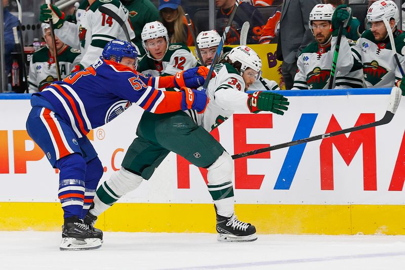 Nov 21, 2024; Edmonton, Alberta, CAN; Edmonton Oilers forward Jeff Skinner (53) knocks Minnesota Wild forward Ryan Hartman (38) off the puck during the first period at Rogers Place. Mandatory Credit: Perry Nelson-Imagn Images