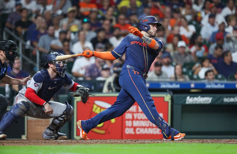 Aug 19, 2024; Houston, Texas, USA; Houston Astros catcher Victor Caratini (17) hits an RBI single during the fourth inning against the Boston Red Sox at Minute Maid Park. Mandatory Credit: Troy Taormina-USA TODAY Sports