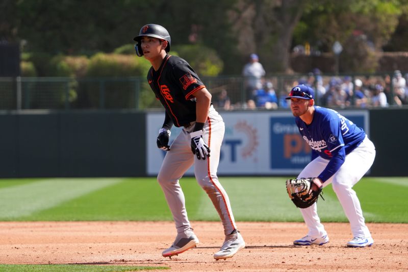 Mar 1, 2025; Phoenix, Arizona, USA; San Francisco Giants outfielder Jung Hoo Lee (51) leads off first as Los Angeles Dodgers first baseman Griffin Lockwood-Powell (72) covers the bag during the third inning at Camelback Ranch-Glendale. Mandatory Credit: Joe Camporeale-Imagn Images