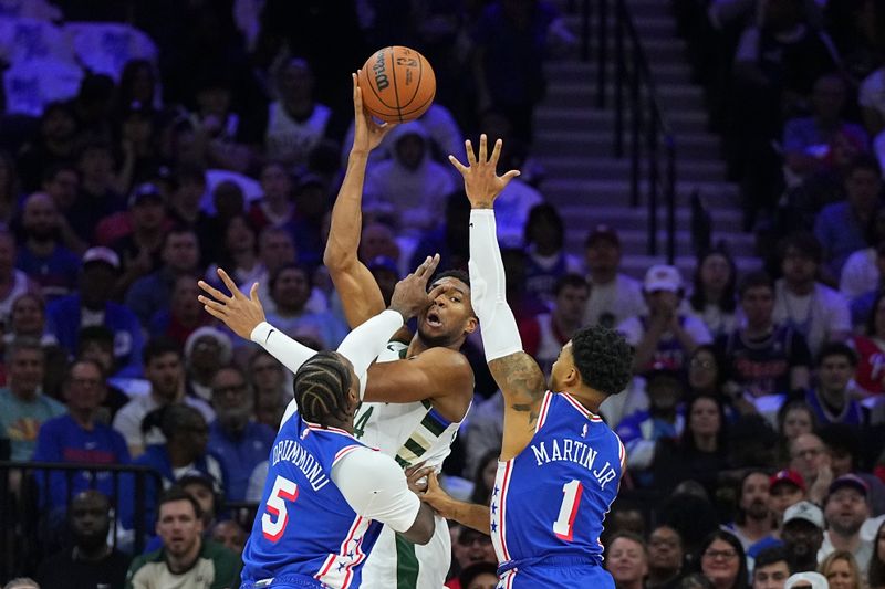 PHILADELPHIA, PENNSYLVANIA - OCTOBER 23: Giannis Antetokounmpo #34 of the Milwaukee Bucks passes the ball against Andre Drummond #5 and KJ Martin #1 of the Philadelphia 76ers in the first half at the Wells Fargo Center on October 23, 2024 in Philadelphia, Pennsylvania. NOTE TO USER: User expressly acknowledges and agrees that, by downloading and/or using this photograph, user is consenting to the terms and conditions of the Getty Images License Agreement. (Photo by Mitchell Leff/Getty Images)