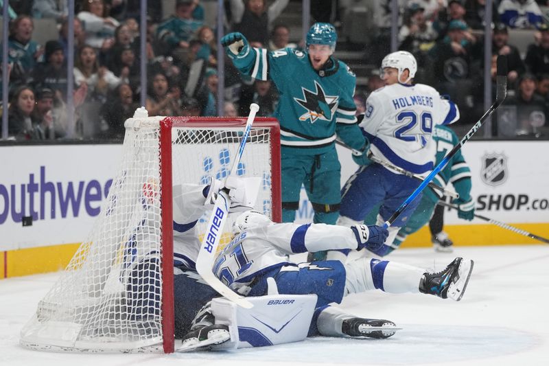 Jan 3, 2026; San Jose, California, USA; Tampa Bay Lightning goaltender Andrei Vasilevskiy (left) and defenseman Charle-Edouard D'Astous (center on ice) fall into the net as a goal is scored by San Jose Sharks left wing Pavol Regenda (center top) during the second period at SAP Center at San Jose. Mandatory Credit: Darren Yamashita-Imagn Images