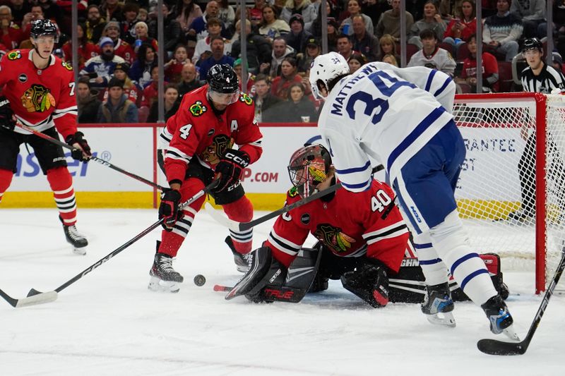 Nov 24, 2023; Chicago, Illinois, USA; Chicago Blackhawks goaltender Arvid Soderblom (40) makes a save on Toronto Maple Leafs center Auston Matthews (34) during the first period at United Center. Mandatory Credit: David Banks-USA TODAY Sports