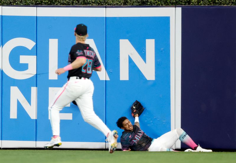 May 31, 2025; Miami, Florida, USA;  Miami Marlins right fielder Kyle Stowers (28) watches center fielder Dane Myers (54) catch a ball off the wall in the outfield against the San Francisco Giants during the first seventh at loanDepot Park. Mandatory Credit: Rhona Wise-Imagn Images