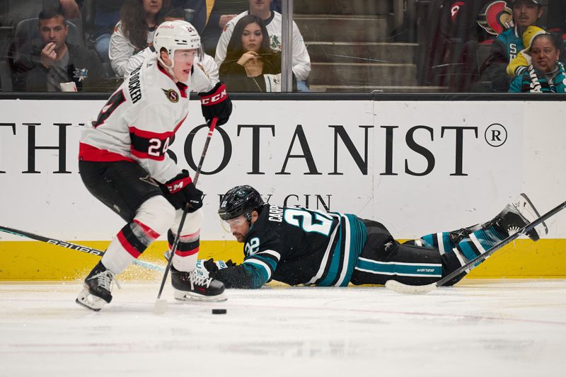 Mar 9, 2024; San Jose, California, USA; Ottawa Senators defenseman Jacob Bernard-Docker (24) plays the puck against San Jose Sharks center Ryan Carpenter (22) during the second period at SAP Center at San Jose. Mandatory Credit: Robert Edwards-USA TODAY Sports