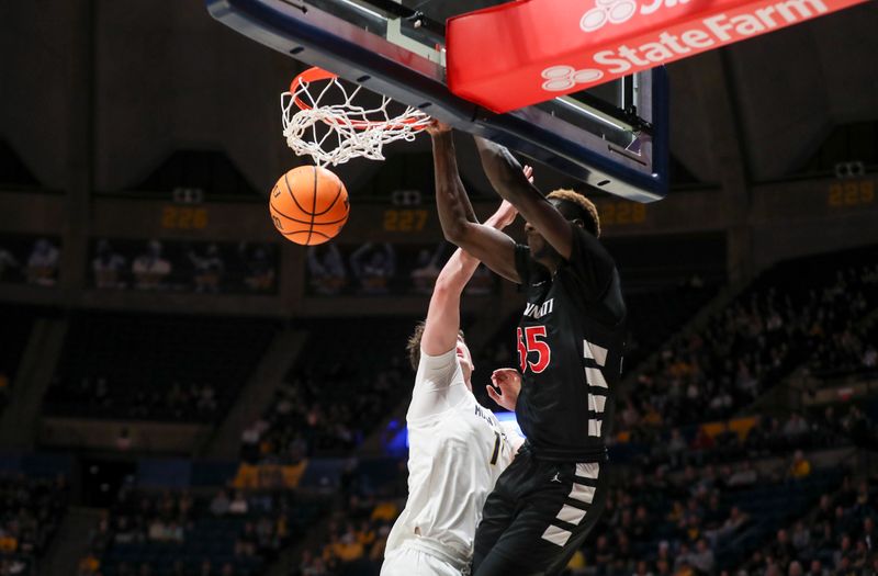 Jan 31, 2024; Morgantown, West Virginia, USA; Cincinnati Bearcats forward Aziz Bandaogo (55) dunks the ball over West Virginia Mountaineers forward Quinn Slazinski (11) during the first half at WVU Coliseum. Mandatory Credit: Ben Queen-USA TODAY Sports