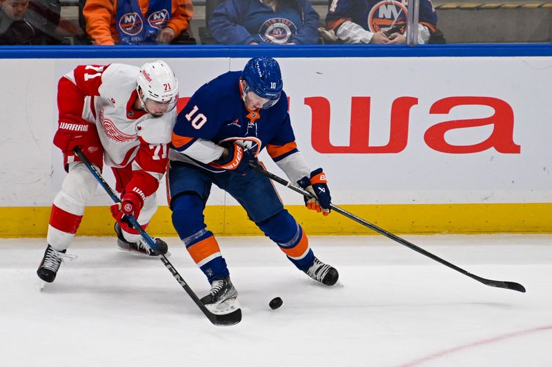 Nov 25, 2024; Elmont, New York, USA;  New York Islanders right wing Simon Holmstrom (10) and Detroit Red Wings center Dylan Larkin (71) battle for the puck during the first period at UBS Arena. Mandatory Credit: Dennis Schneidler-Imagn Images