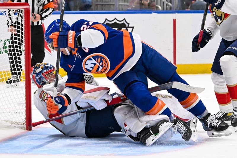 Oct 26, 2024; Elmont, New York, USA;  Florida Panthers goaltender Spencer Knight (30) makes a save as New York Islanders left wing Anders Lee (27) falls into him during the second period at UBS Arena. Mandatory Credit: Dennis Schneidler-Imagn Images