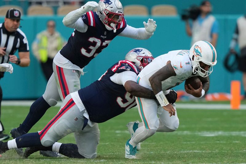 New England Patriots defensive tackle Christian Barmore (90) sacks Miami Dolphins quarterback Tua Tagovailoa (1) during the second half of an NFL football game, Sunday, Nov. 24, 2024, in Miami Gardens, Fla. (AP Photo/Lynne Sladky)