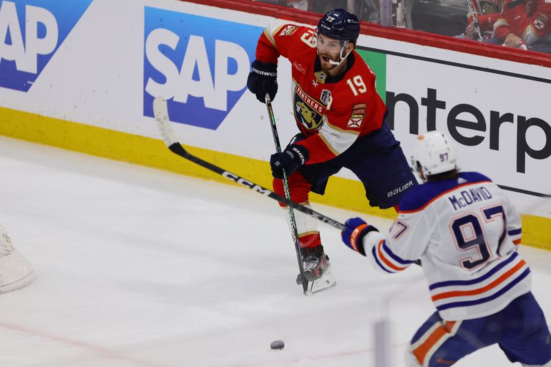 Jun 10, 2024; Sunrise, Florida, USA; Florida Panthers forward Matthew Tkachuk (19) skates with the puck against Edmonton Oilers forward Connor McDavid (97) during the third period in game two of the 2024 Stanley Cup Final at Amerant Bank Arena. Mandatory Credit: Sam Navarro-USA TODAY Sports