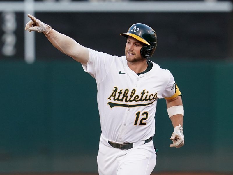 Jul 19, 2024; Oakland, California, USA; Oakland Athletics shortstop Max Schuemann (12) points towards left field after hitting a three-run home run against the Los Angeles Angels in the fourth inning at Oakland-Alameda County Coliseum. Mandatory Credit: Cary Edmondson-USA TODAY Sports