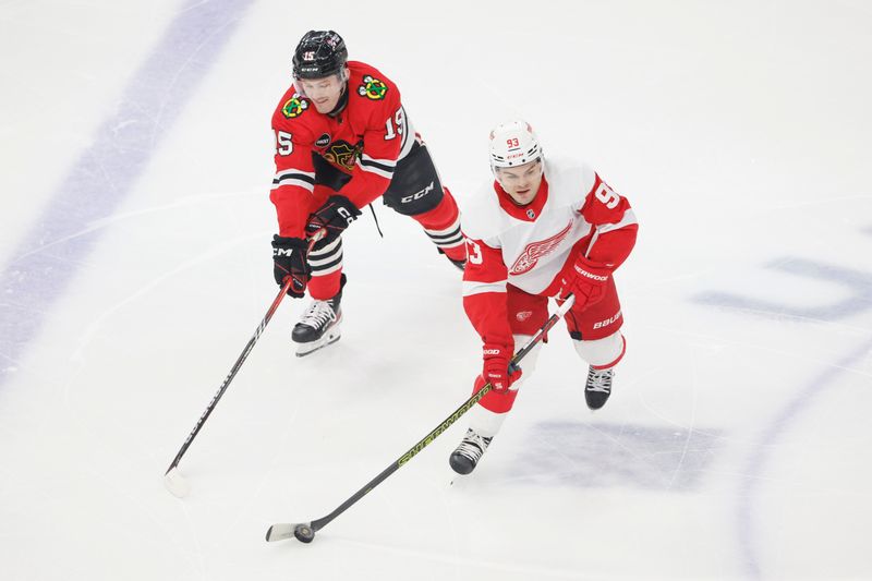 Feb 25, 2024; Chicago, Illinois, USA; Chicago Blackhawks right wing Joey Anderson (15) battles for the puck with Detroit Red Wings right wing Alex DeBrincat (93) during the first period at United Center. Mandatory Credit: Kamil Krzaczynski-USA TODAY Sports