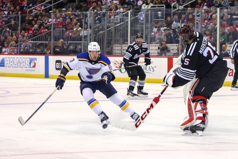 Nov 27, 2024; Newark, New Jersey, USA; New Jersey Devils goaltender Jacob Markstrom (25) plays the puck away from St. Louis Blues left wing Jake Neighbours (63) during the third period at Prudential Center. Mandatory Credit: Ed Mulholland-Imagn Images