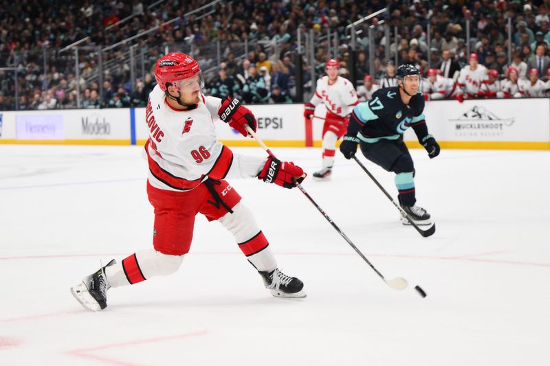 Oct 26, 2024; Seattle, Washington, USA; Carolina Hurricanes center Jack Roslovic (96) shoots the puck against the Seattle Kraken during the second period at Climate Pledge Arena. Mandatory Credit: Steven Bisig-Imagn Images