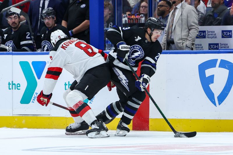 Nov 16, 2024; Tampa, Florida, USA; Tampa Bay Lightning center Michael Eyssimont (23) and New Jersey Devils defenseman Johnathan Kovacevic (8) battle for the puck in the first period at Amalie Arena. Mandatory Credit: Nathan Ray Seebeck-Imagn Images