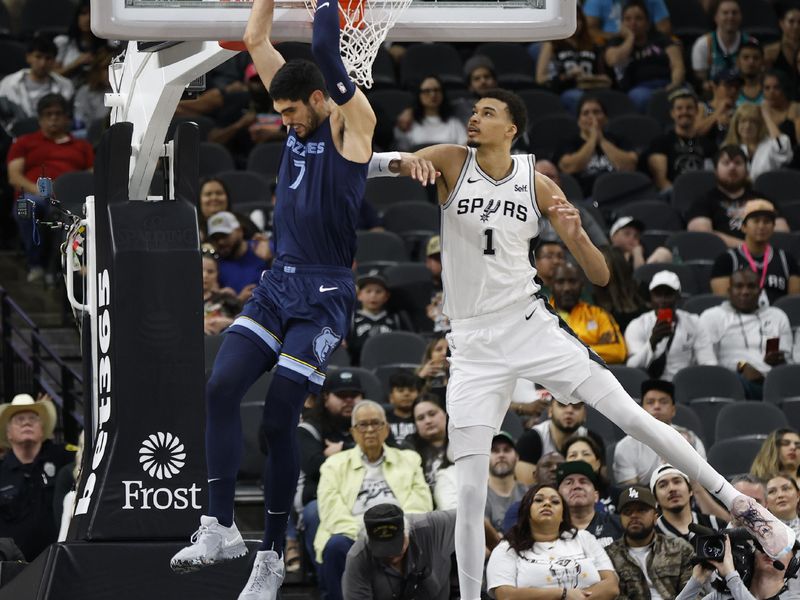 SAN ANTONIO, TX - MARCH 22:  Victor Wembanyama #1 of the San Antonio Spurs watches as Santi Aldama #7 of the Memphis Grizzlies do a reverse dunk in the first half at Frost Bank Center on March 22, 2024 in San Antonio, Texas. NOTE TO USER: User expressly acknowledges and agrees that, by downloading and or using this photograph, User is consenting to terms and conditions of the Getty Images License Agreement. (Photo by Ronald Cortes/Getty Images)