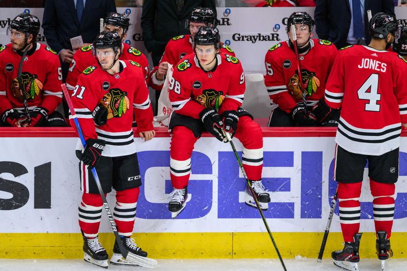 Dec 10, 2023; Chicago, Illinois, USA; Chicago Blackhawks center Connor Bedard (98) sits on the board during a break in play against the Washington Capitals during the third period at the United Center. Mandatory Credit: Daniel Bartel-USA TODAY Sports