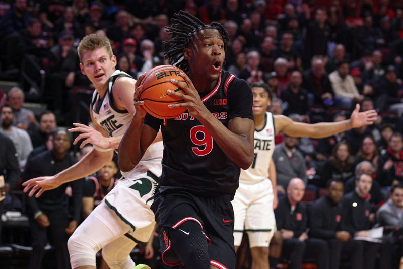 Jan 27, 2026; Piscataway, New Jersey, USA; Rutgers Scarlet Knights forward Dylan Grant (9) goes to the basket in front of Michigan State Spartans forward Jaxon Kohler (0) and guard Jeremy Fears Jr. (1) during the second half at Jersey Mike's Arena. Mandatory Credit: Vincent Carchietta-Imagn Images